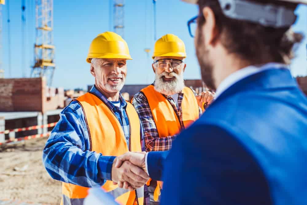construction-worker-in-protective-uniform-shaking hands